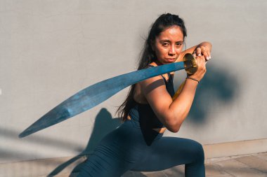 Çinli genç bir kadın dışarıda Wushu kung fu 'su yapıyor. Dövüş sanatları eğitimi alan genç bir kız..