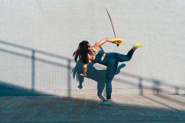 Çinli genç bir kadın dışarıda Wushu kung fu 'su yapıyor. Dövüş sanatları eğitimi alan genç bir kız..