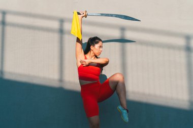 Çinli genç bir kadın dışarıda Wushu kung fu 'su yapıyor. Dövüş sanatları eğitimi alan genç bir kız..