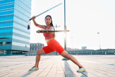 Çinli genç bir kadın dışarıda Wushu kung fu 'su yapıyor. Dövüş sanatları eğitimi alan genç bir kız..