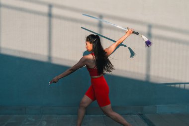 Çinli genç bir kadın dışarıda Wushu kung fu 'su yapıyor. Dövüş sanatları eğitimi alan genç bir kız..