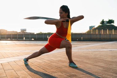 Çinli genç bir kadın dışarıda Wushu kung fu 'su yapıyor. Dövüş sanatları eğitimi alan genç bir kız..
