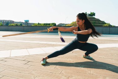 Çinli genç bir kadın dışarıda Wushu kung fu 'su yapıyor. Dövüş sanatları eğitimi alan genç bir kız..