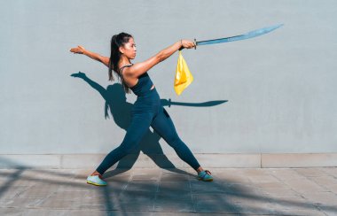 Çinli genç bir kadın dışarıda Wushu kung fu 'su yapıyor. Dövüş sanatları eğitimi alan genç bir kız..