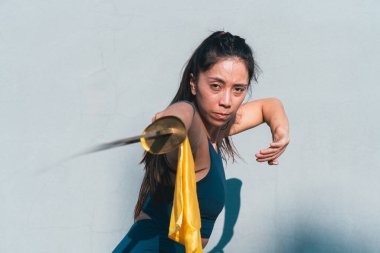 Çinli genç bir kadın dışarıda Wushu kung fu 'su yapıyor. Dövüş sanatları eğitimi alan genç bir kız..