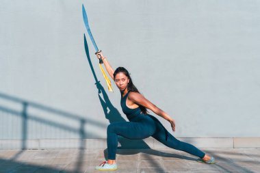 Çinli genç bir kadın dışarıda Wushu kung fu 'su yapıyor. Dövüş sanatları eğitimi alan genç bir kız..