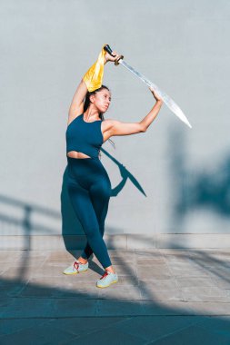 Çinli genç bir kadın dışarıda Wushu kung fu 'su yapıyor. Dövüş sanatları eğitimi alan genç bir kız..