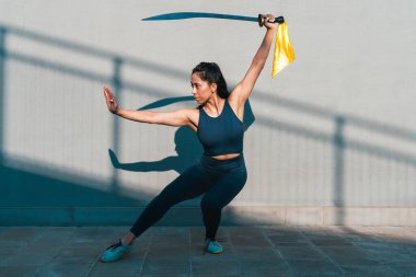 Çinli genç bir kadın dışarıda Wushu kung fu 'su yapıyor. Dövüş sanatları eğitimi alan genç bir kız..