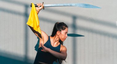 Çinli genç bir kadın dışarıda Wushu kung fu 'su yapıyor. Dövüş sanatları eğitimi alan genç bir kız..