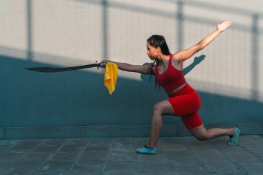 Çinli genç bir kadın dışarıda Wushu kung fu 'su yapıyor. Dövüş sanatları eğitimi alan genç bir kız..