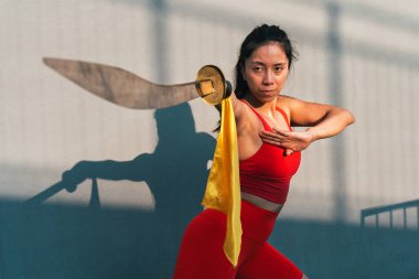 Çinli genç bir kadın dışarıda Wushu kung fu 'su yapıyor. Dövüş sanatları eğitimi alan genç bir kız..