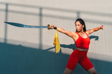 Çinli genç bir kadın dışarıda Wushu kung fu 'su yapıyor. Dövüş sanatları eğitimi alan genç bir kız..
