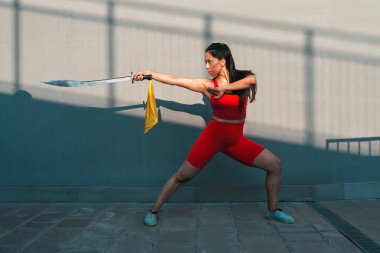 Çinli genç bir kadın dışarıda Wushu kung fu 'su yapıyor. Dövüş sanatları eğitimi alan genç bir kız..