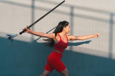 Çinli genç bir kadın dışarıda Wushu kung fu 'su yapıyor. Dövüş sanatları eğitimi alan genç bir kız..