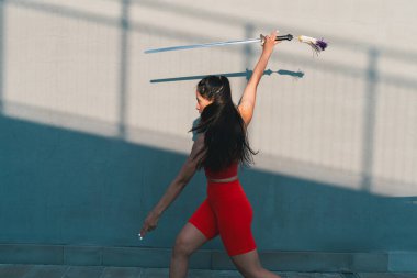 Çinli genç bir kadın dışarıda Wushu kung fu 'su yapıyor. Dövüş sanatları eğitimi alan genç bir kız..