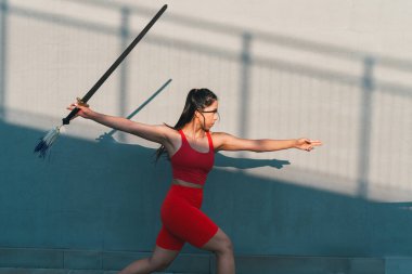 Çinli genç bir kadın dışarıda Wushu kung fu 'su yapıyor. Dövüş sanatları eğitimi alan genç bir kız..