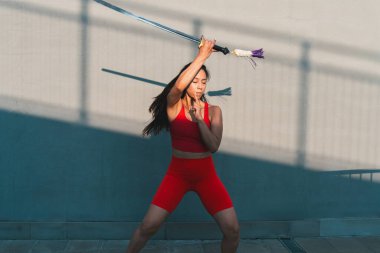 Çinli genç bir kadın dışarıda Wushu kung fu 'su yapıyor. Dövüş sanatları eğitimi alan genç bir kız..