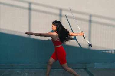 Çinli genç bir kadın dışarıda Wushu kung fu 'su yapıyor. Dövüş sanatları eğitimi alan genç bir kız..