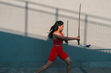 Çinli genç bir kadın dışarıda Wushu kung fu 'su yapıyor. Dövüş sanatları eğitimi alan genç bir kız..