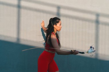 Çinli genç bir kadın dışarıda Wushu kung fu 'su yapıyor. Dövüş sanatları eğitimi alan genç bir kız..