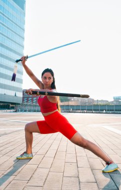 Çinli genç bir kadın dışarıda Wushu kung fu 'su yapıyor. Dövüş sanatları eğitimi alan genç bir kız..