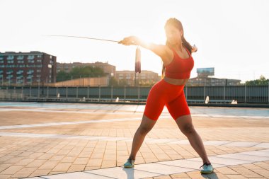 Çinli genç bir kadın dışarıda Wushu kung fu 'su yapıyor. Dövüş sanatları eğitimi alan genç bir kız..