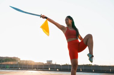 Çinli genç bir kadın dışarıda Wushu kung fu 'su yapıyor. Dövüş sanatları eğitimi alan genç bir kız..