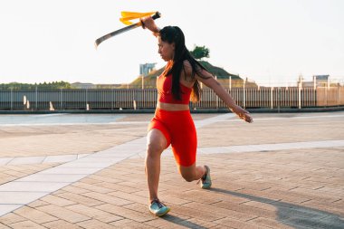 Çinli genç bir kadın dışarıda Wushu kung fu 'su yapıyor. Dövüş sanatları eğitimi alan genç bir kız..
