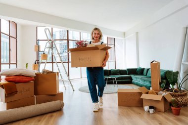 Bekar bir kadın yeni bir daireye taşınıyor. Orta yaşlı, son sınıf güzel bir kadın yeni evde kutuları falan taşıyor. Yaşam tarzı ve gayrimenkul kavramı.