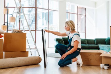 Bekar bir kadın yeni bir daireye taşınıyor. Orta yaşlı, son sınıf güzel bir kadın yeni evde kutuları falan taşıyor. Yaşam tarzı ve gayrimenkul kavramı.