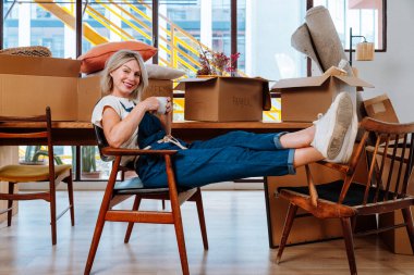 Bekar bir kadın yeni bir daireye taşınıyor. Orta yaşlı, son sınıf güzel bir kadın yeni evde kutuları falan taşıyor. Yaşam tarzı ve gayrimenkul kavramı.