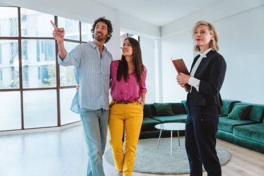 Emlakçı yeni bir daire gösteriyor ve genç bir çifte iyi bir yatırım yapıyor. Kadın ve erkek şehrin zengin bir bölgesinde mülk satın alıyorlar..