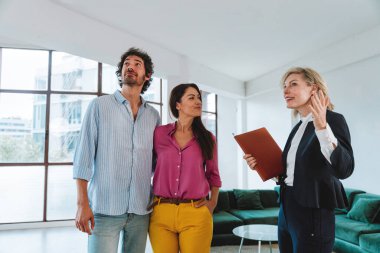 Emlakçı yeni bir daire gösteriyor ve genç bir çifte iyi bir yatırım yapıyor. Kadın ve erkek şehrin zengin bir bölgesinde mülk satın alıyorlar..