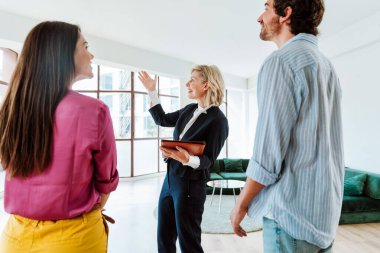 Emlakçı yeni bir daire gösteriyor ve genç bir çifte iyi bir yatırım yapıyor. Kadın ve erkek şehrin zengin bir bölgesinde mülk satın alıyorlar..