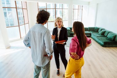 Emlakçı yeni bir daire gösteriyor ve genç bir çifte iyi bir yatırım yapıyor. Kadın ve erkek şehrin zengin bir bölgesinde mülk satın alıyorlar..