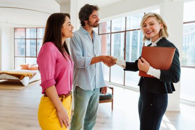 Emlakçı yeni bir daire gösteriyor ve genç bir çifte iyi bir yatırım yapıyor. Kadın ve erkek şehrin zengin bir bölgesinde mülk satın alıyorlar..