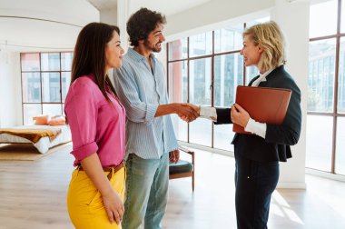 Emlakçı yeni bir daire gösteriyor ve genç bir çifte iyi bir yatırım yapıyor. Kadın ve erkek şehrin zengin bir bölgesinde mülk satın alıyorlar..