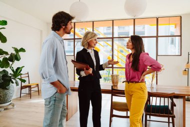 Emlakçı yeni bir daire gösteriyor ve genç bir çifte iyi bir yatırım yapıyor. Kadın ve erkek şehrin zengin bir bölgesinde mülk satın alıyorlar..