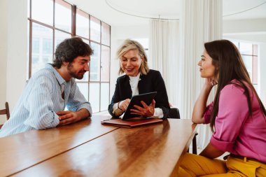 Emlakçı yeni bir daire gösteriyor ve genç bir çifte iyi bir yatırım yapıyor. Kadın ve erkek, şehrin zengin bir bölgesinde mülk satın alıyorlar. Sözleşmeyi imzalıyorum..