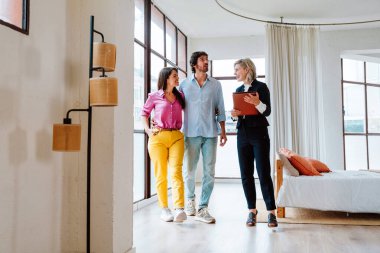 Emlakçı yeni bir daire gösteriyor ve genç bir çifte iyi bir yatırım yapıyor. Kadın ve erkek şehrin zengin bir bölgesinde mülk satın alıyorlar..