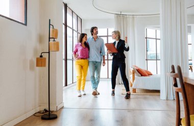 Emlakçı yeni bir daire gösteriyor ve genç bir çifte iyi bir yatırım yapıyor. Kadın ve erkek şehrin zengin bir bölgesinde mülk satın alıyorlar..