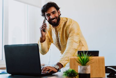 Ofisteki Pakistanlı iş adamı. Ofisinde geleneksel kıyafetleriyle çalışan genç bir iş adamı. Satış elemanı müşterilerle yeni anlaşmalar hakkında konuşuyor..