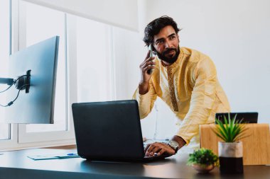 Ofisteki Pakistanlı iş adamı. Ofisinde geleneksel kıyafetleriyle çalışan genç bir iş adamı. Satış elemanı müşterilerle yeni anlaşmalar hakkında konuşuyor..