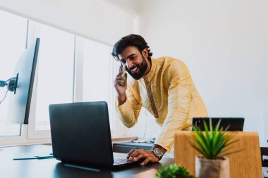 Ofisteki Pakistanlı iş adamı. Ofisinde geleneksel kıyafetleriyle çalışan genç bir iş adamı. Satış elemanı müşterilerle yeni anlaşmalar hakkında konuşuyor..