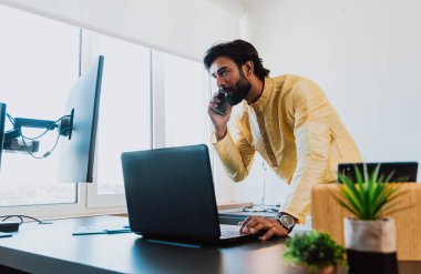 Ofisteki Pakistanlı iş adamı. Ofisinde geleneksel kıyafetleriyle çalışan genç bir iş adamı. Satış elemanı müşterilerle yeni anlaşmalar hakkında konuşuyor..