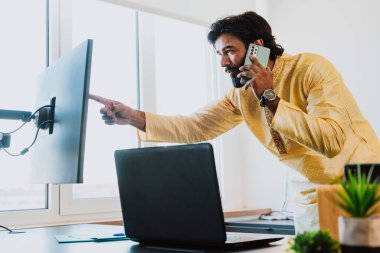 Ofisteki Pakistanlı iş adamı. Ofisinde geleneksel kıyafetleriyle çalışan genç bir iş adamı. Satış elemanı müşterilerle yeni anlaşmalar hakkında konuşuyor..