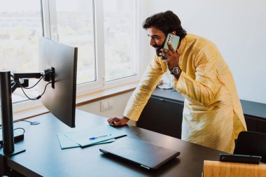 Ofisteki Pakistanlı iş adamı. Ofisinde geleneksel kıyafetleriyle çalışan genç bir iş adamı. Satış elemanı müşterilerle yeni anlaşmalar hakkında konuşuyor..