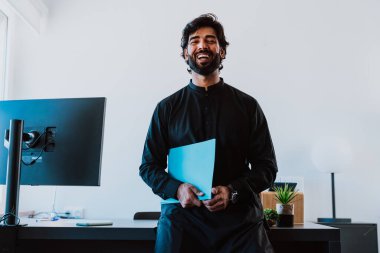 Ofisteki Pakistanlı iş adamı. Geleneksel kıyafetleri olan genç bir iş adamı ofisinde çalışıyor..