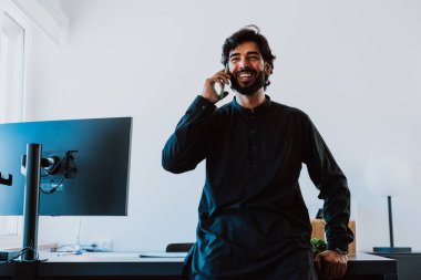 Ofisteki Pakistanlı iş adamı. Geleneksel kıyafetleri olan genç bir iş adamı ofisinde çalışıyor..