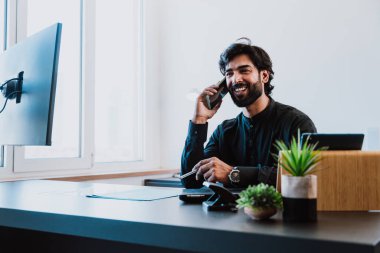 Ofisteki Pakistanlı iş adamı. Geleneksel kıyafetleri olan genç bir iş adamı ofisinde çalışıyor..